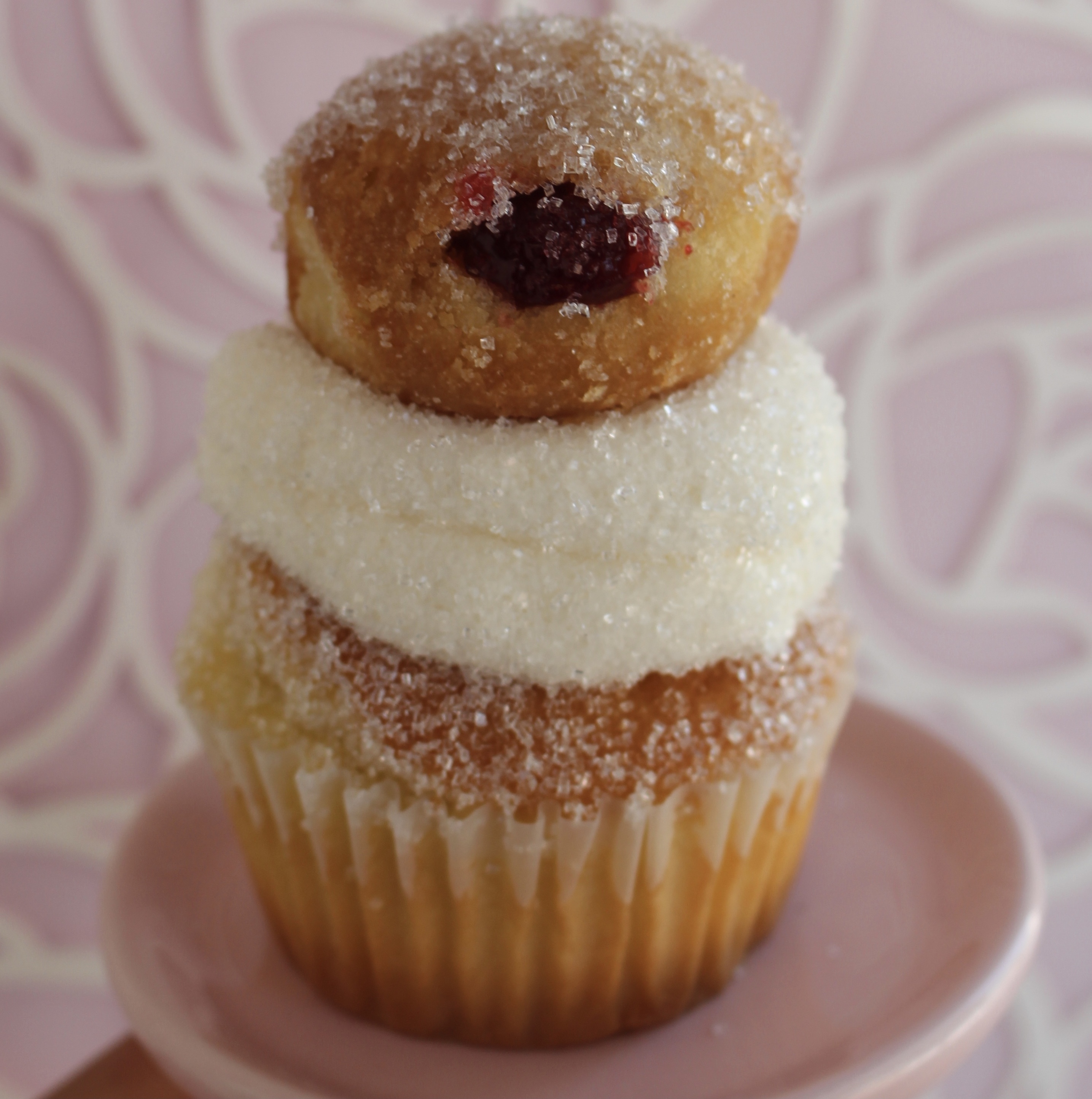 Vanilla cake filled with raspberry jelly, topped with vanilla buttercream and a mini jelly donut!