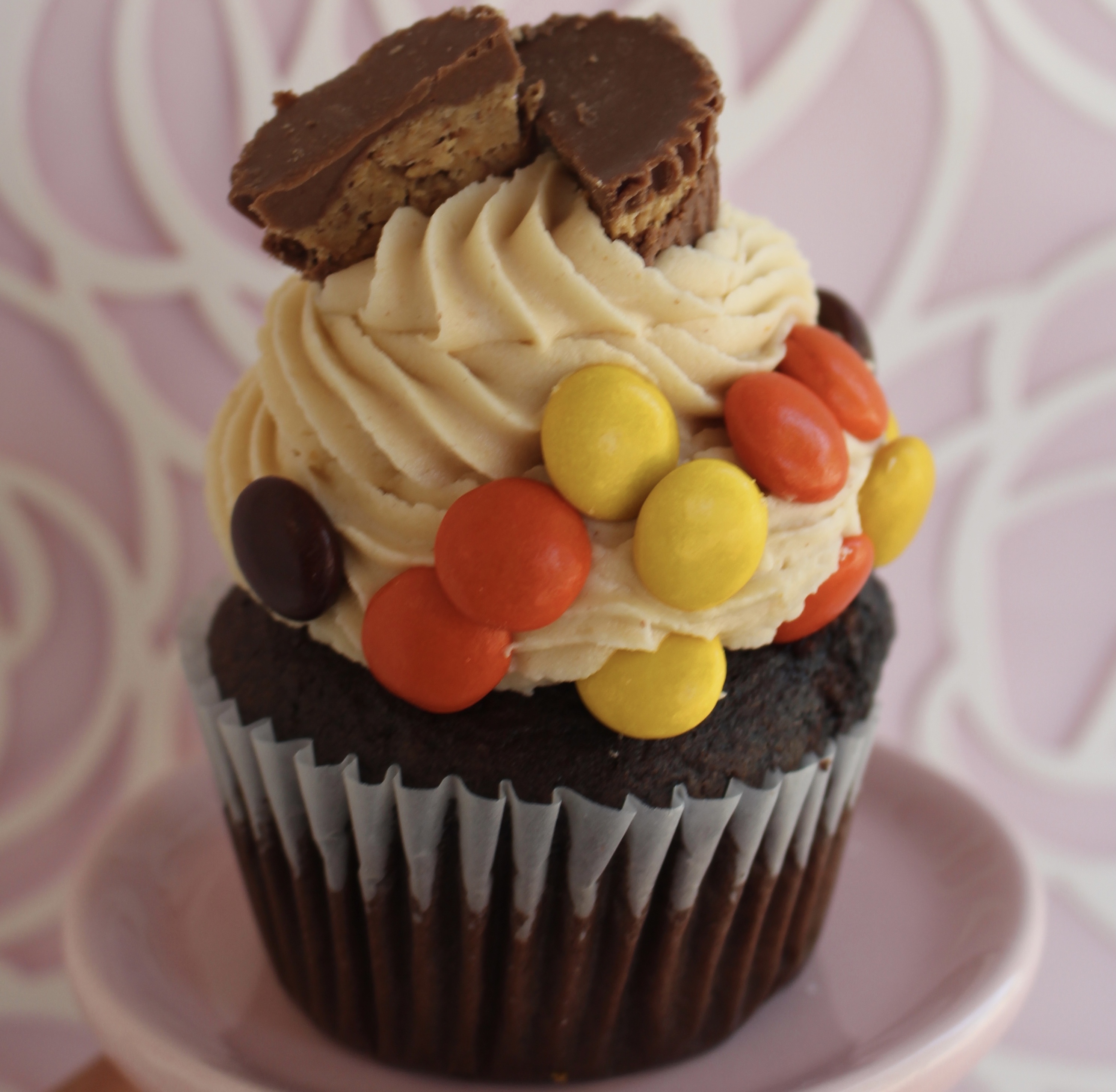 Chocolate or vanilla cake filled with reese's pieces, topped with peanut butter buttercream, more reese's pieces, and a mini peanut butter cup!